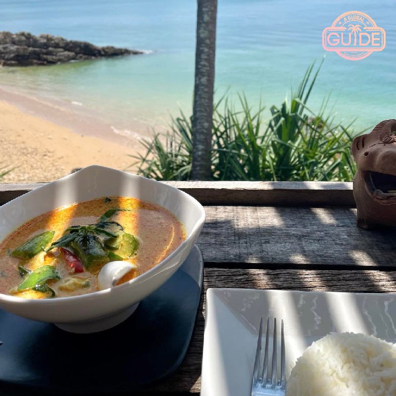 Red curry soup, steamed rice with the brach and ocean in the background